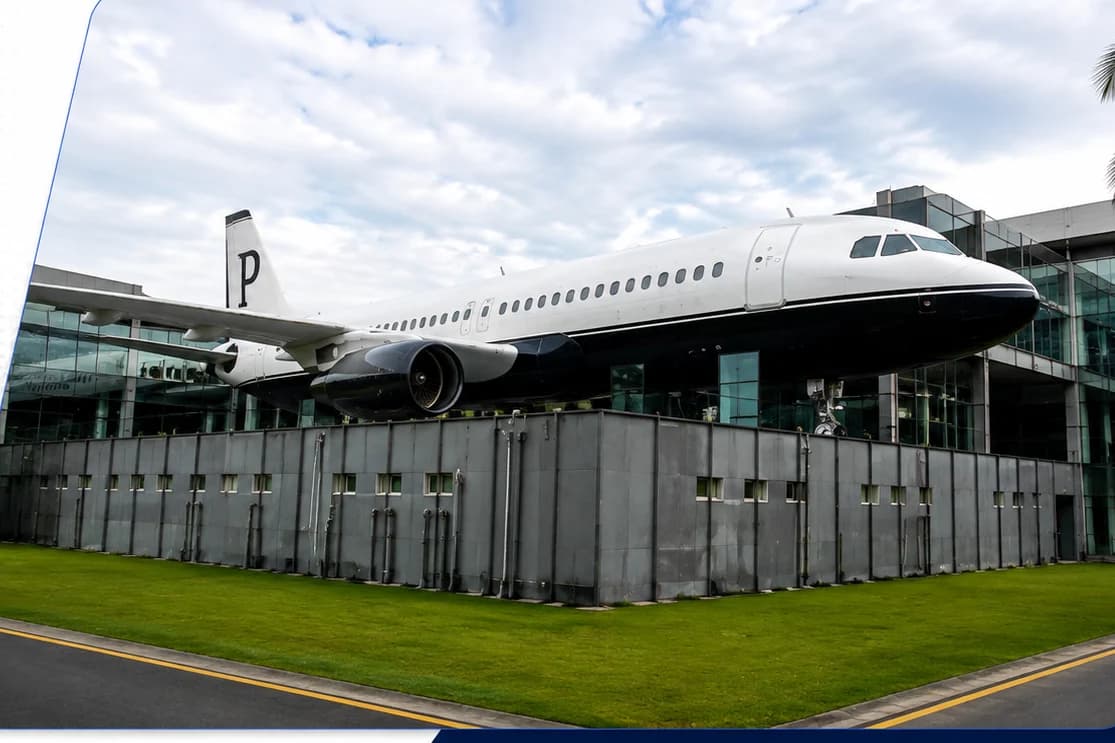 A black-and-white liveried airliner with a 'P' on its tail converted into a corporate office on the rooftop of a glass building in Pune